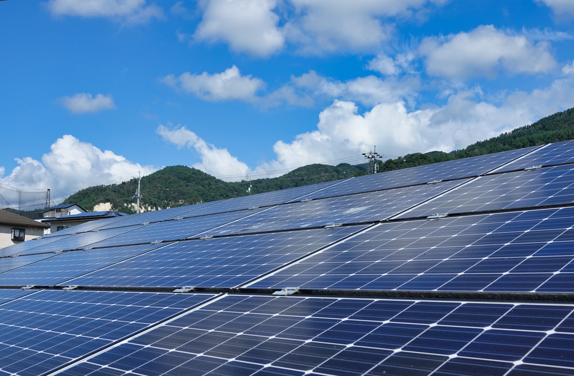 屋根に設置された太陽光発電パネルと青空